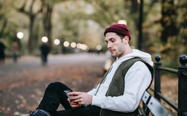 Man sitting on beach looking at his phone